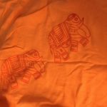Red elephants stamped on an orange t-shirt
