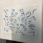 T-shirt painted with freeform lines in blue and gold