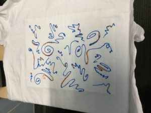 T-shirt painted with freeform lines in blue and gold